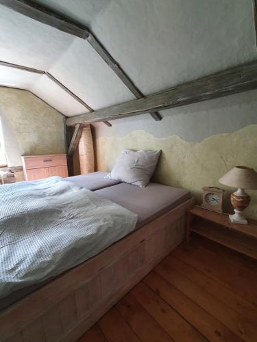 a bedroom with a bed in a room with a roof at Chalupa Království in Šluknov