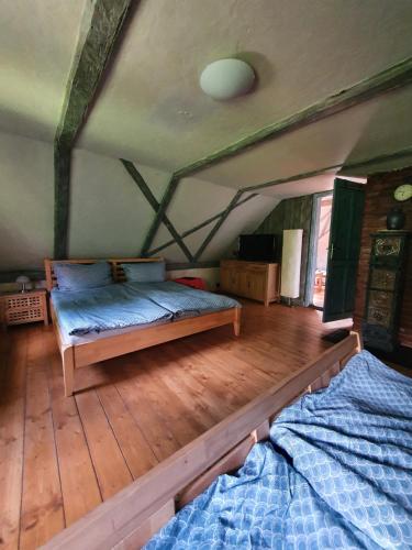 a bedroom with two beds and a wooden floor at Chalupa Království in Šluknov