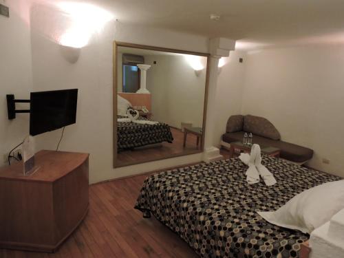 Habitación de hotel con cama y espejo en Motel Mykonos en Puebla
