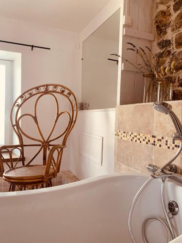 a bath tub in a bathroom with a chair at LE DOMAINE DE COAT ROGAN, La chambre du Tregor in Ploëzal
