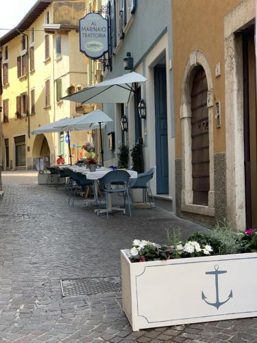 an outdoor patio with tables and umbrellas on a street at Al Lago da Lilly in Gargnano