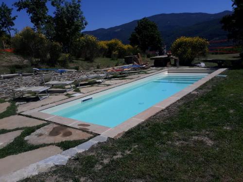 a swimming pool with blue water in a yard at I Poggi di Belvedere in Cerbaiolo