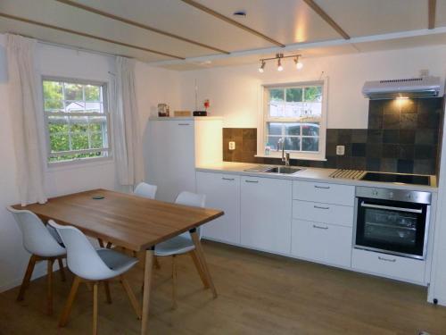 奧斯特韋克的住宿－Vakantiehuis Appelvink, Toplocatie in bosrijke omgeving，厨房配有木桌和白色橱柜。