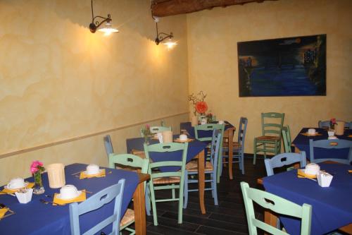 a dining room with blue tables and chairs at Le Calvie, country house in Camerino