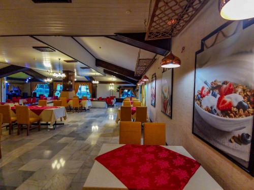 a restaurant with tables and chairs and a bowl of food at Hotel Belvedere in Predeal