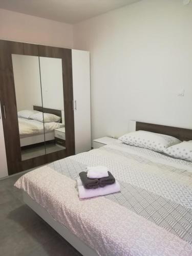 1 Schlafzimmer mit 2 Betten, einem Spiegel und einem lila Handtuch in der Unterkunft Plava laguna Miroslav in Crikvenica