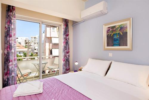 ハニア・タウンにあるMelina Apartmentsの大きなベッドとバルコニーのある寝室