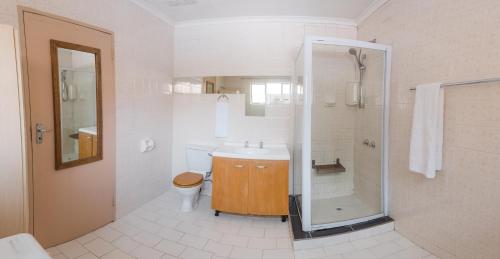 a bathroom with a shower and a sink and a toilet at Comfy Menlyn Maine Appartment in Pretoria