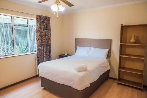 a bedroom with a bed and a large window at Comfy Menlyn Maine Appartment in Pretoria