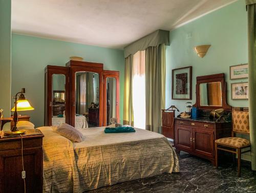 a bedroom with a bed and a dresser and a mirror at Villa il Vento e il Mare in Selargius