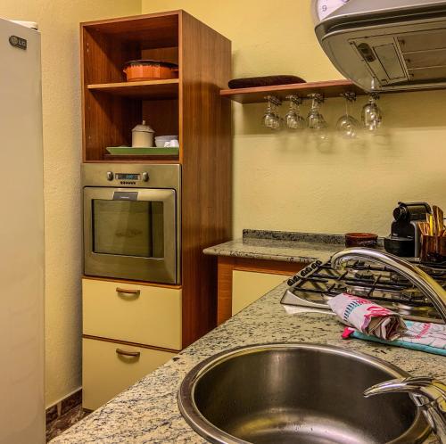 a kitchen with a sink and a microwave at Villa il Vento e il Mare in Selargius