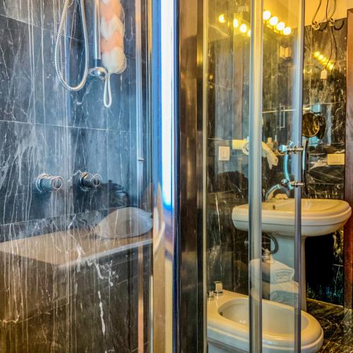 a bathroom with a shower with a toilet and a sink at Villa il Vento e il Mare in Selargius