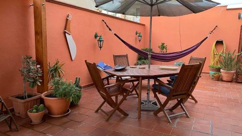 a patio with a table and chairs and an umbrella at Villa il Vento e il Mare in Selargius