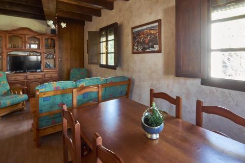 een eetkamer met een tafel en stoelen en een televisie bij casa el susurro in Ponferrada