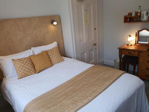 a bedroom with a bed and a dresser with a mirror at The Carre Arms Hotel & Restaurant in Sleaford