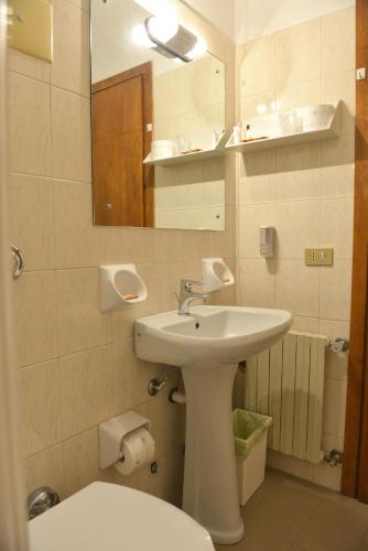a bathroom with a sink and a toilet and a mirror at Taverna Affittacamere in Gardone Riviera