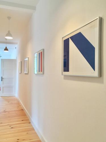 a hallway with paintings on a white wall at Künstlerhaus in Niebüll