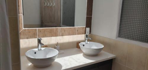 a bathroom with two sinks and a mirror at Chambres d'hôtes Les Sarments in Saint-Pierre-dʼOléron