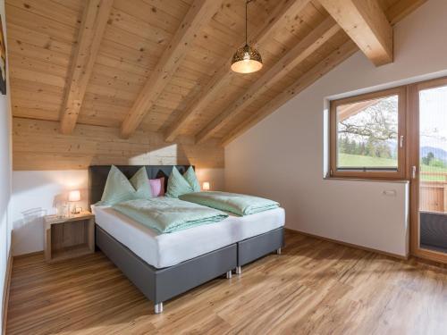 - une chambre avec un lit dans une pièce dotée de plafonds en bois dans l'établissement Ferienwohnung Obersteintal, à Söll