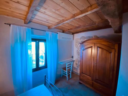 a bedroom with blue curtains and a wooden cabinet at L’Oca Giuliva Relais in Gaggio Montano