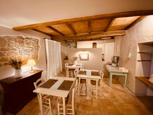 L’Oca Giuliva Relais في Gaggio Montano: غرفة مع طاولات وكراسي في غرفة