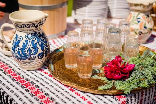 una mesa con un plato de vasos y un jarrón en Casa Ciortea Ana, en Sibiel
