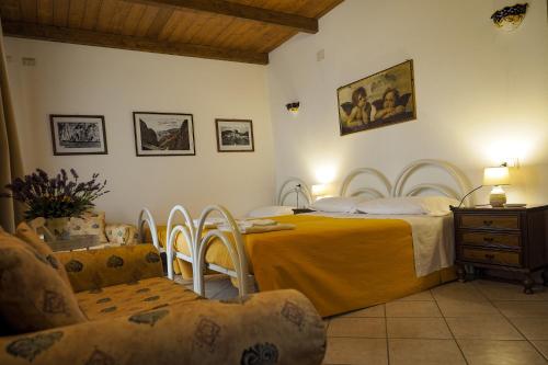 a bedroom with a bed and a table and chairs at La Vecchia Montagna B&B in Nebida