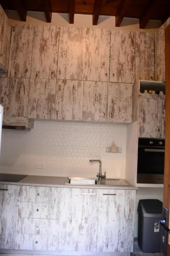a kitchen with wooden cabinets and a sink at Lazaros Stonehouse in Pano Lefkara
