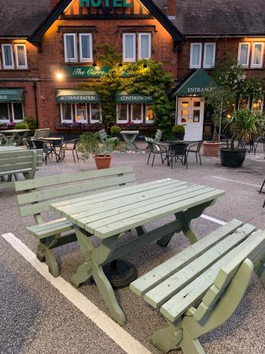 a picnic table and benches in front of a building at The Carre Arms Hotel & Restaurant in Sleaford