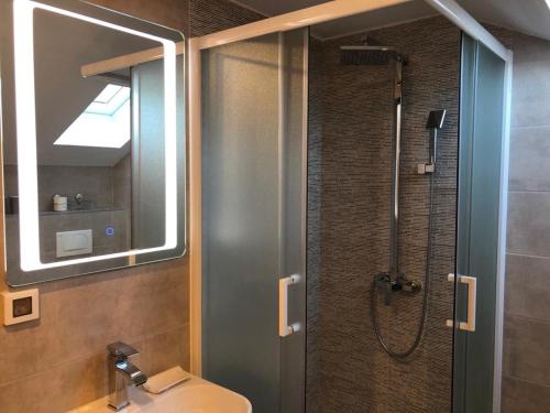 uma casa de banho com um chuveiro, um lavatório e um espelho. em Apartments ADRIATIC Rab em Rab