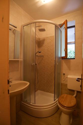 een badkamer met een douche, een toilet en een wastafel bij Romantic room with balcony in Lovran