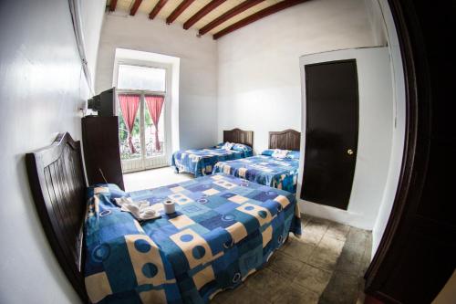 a room with two beds and a mirror at La Fuente Catedral in Puebla