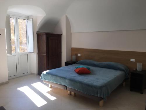 Un dormitorio con una cama con una almohada roja. en Case Rossa e Blu, en Villanova dʼAlbenga