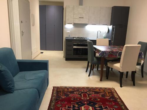 salon z niebieską kanapą i stołem z krzesłami w obiekcie Case Rossa e Blu w mieście Villanova dʼAlbenga