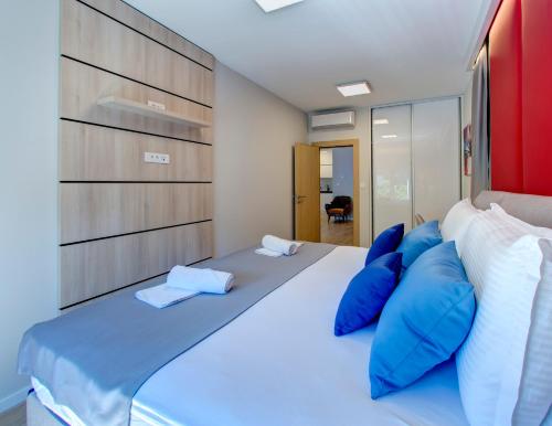 a bedroom with a large bed with blue pillows at Luxury apartment Concept in Mostar