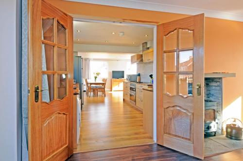 a kitchen with a door open to a dining room at Whitby Spacious Rugby Field Cottage with off-street parking and EV fast point for electric cars in Whitby