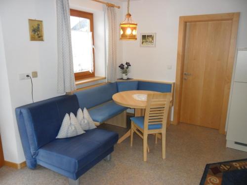 a living room with a blue couch and a table at Maurerhof Telves in Racines