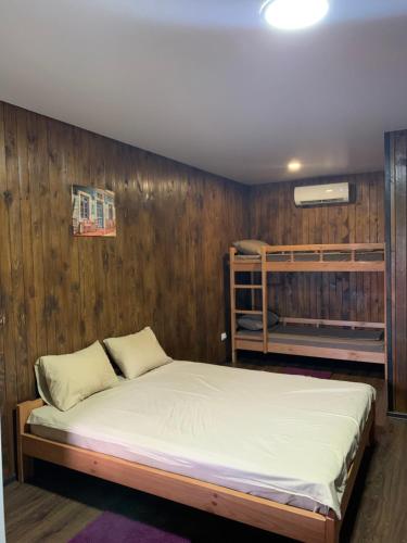 a bed in a room with a wooden wall at Мини-отель Sunrise-Bugaz in Zatoka