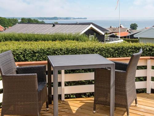 Hejlsにある8 person holiday home in Sj lundの海の景色を望むデッキ(テーブル、椅子付)