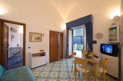 a living room with a table and a dining room at La Caravella di Positano - Relais, Beach & Residences in Positano