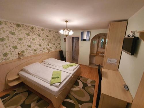 sypialnia z łóżkiem z zieloną serwetką w obiekcie Platán Szálláshely w mieście Sándorfalva