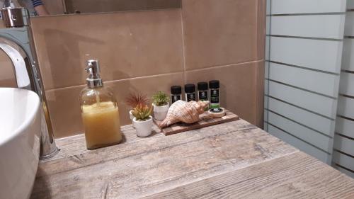 w łazience znajduje się blat z butelką oleju i roślin w obiekcie Room near the Airport w mieście Pikérmion