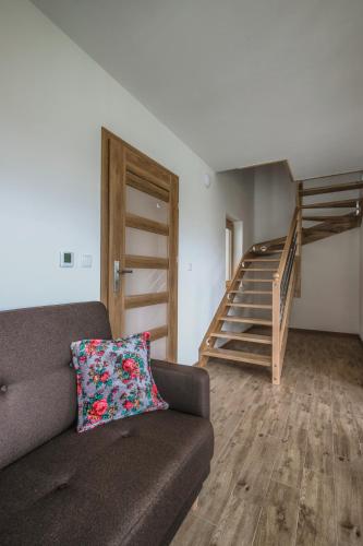 a living room with a couch and a staircase at Domki Sówka in Dursztyn
