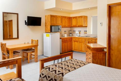 a kitchen with wooden cabinets and a white refrigerator at Hotel Santa Fe Loreto by Villa Group in Loreto