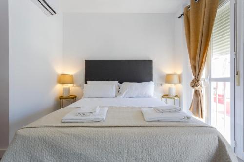 a bedroom with a large bed with two towels on it at Atico de los FRANCESES by Cadiz4Rentals in Cádiz