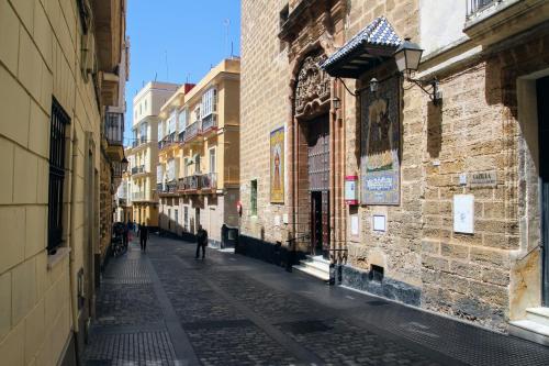 an alley with a person walking down a street at Atico de los FRANCESES by Cadiz4Rentals in Cádiz