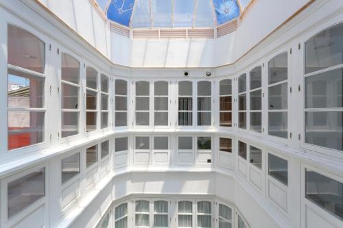 an empty room with white walls and windows at Atico de los FRANCESES by Cadiz4Rentals in Cádiz