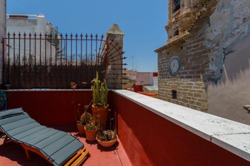 a balcony with a bench and a clock on a building at Atico de los FRANCESES by Cadiz4Rentals in Cádiz