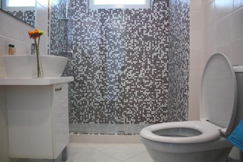 a bathroom with a toilet and a sink and a shower at Guest House ASK in Primorsko