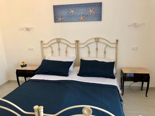 a bedroom with a blue and white bed with two tables at Via Aurispa 60 in Palermo